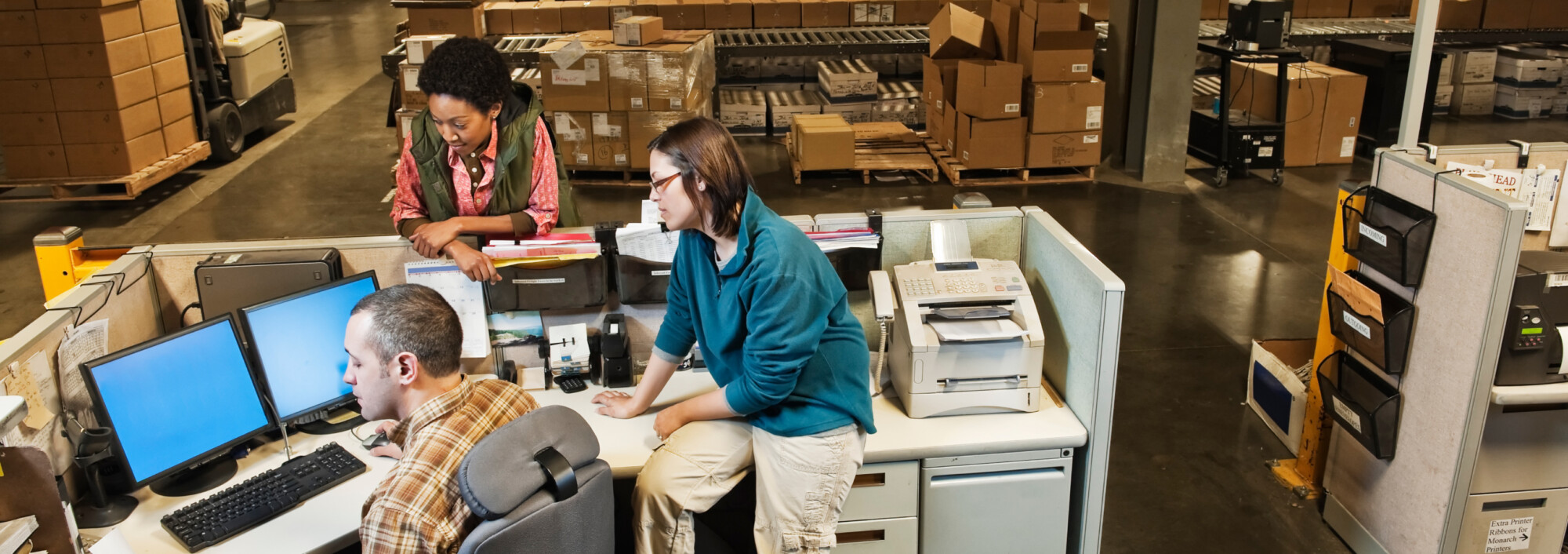 People looking at a computer in a warehouse